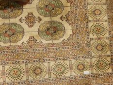 Eastern-style carpet, the beige ground with central field of quartered elephants foot guls,