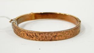 9ct gold hinged bangle with floral engraved decoration, approx. 8.