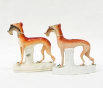 Two Staffordshire models of greyhounds, both with rabbits in their mouths, on naturalistic bases,