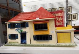 A 20th century doll's house with red roof and garage,