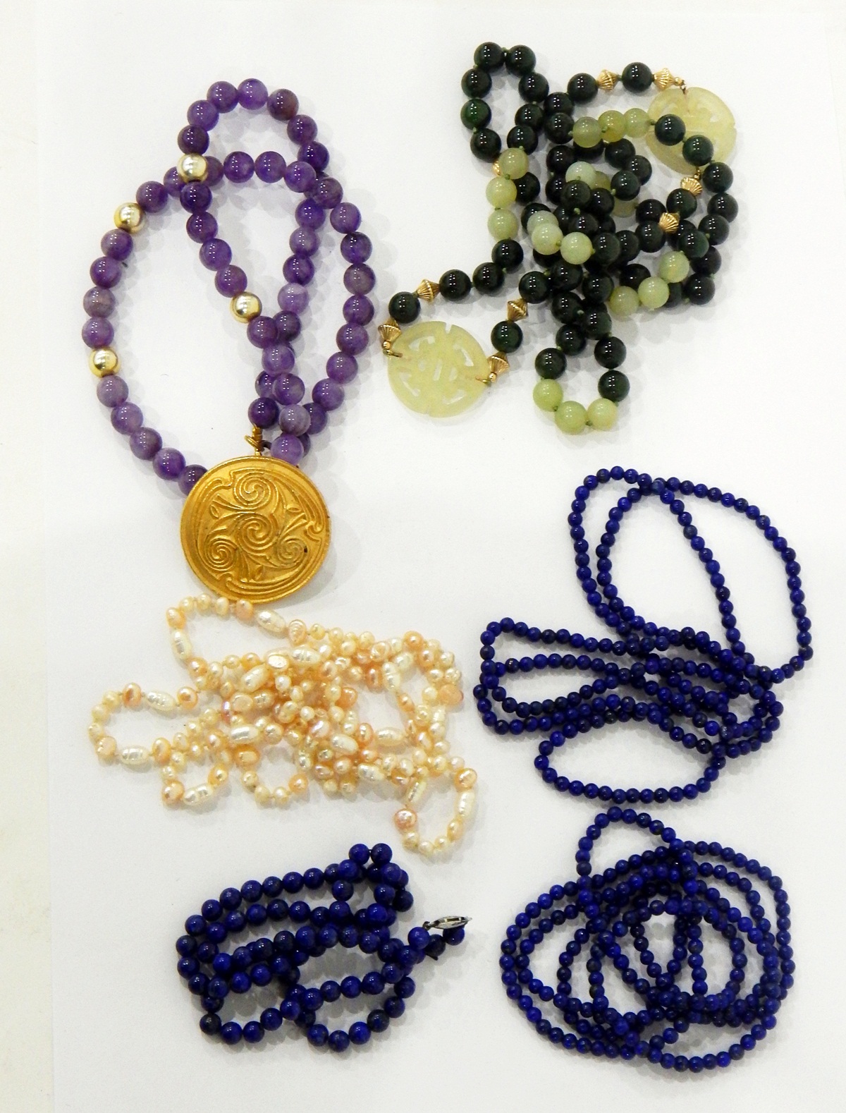 Three lapis bead necklaces, jade bead and pierced disc necklace,