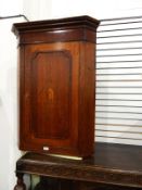 Late 18th/early 19th century oak hanging corner cupboard, the door with conch shell inlay,