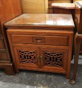 Oriental teak bedside cupboard fitted a drawer and cupboard below, with pierced carved panel doors,