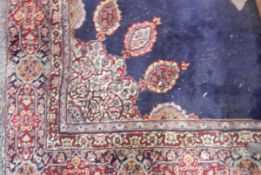A Persian style wool rug having blue ground and red borders, floral and geometric pattern,