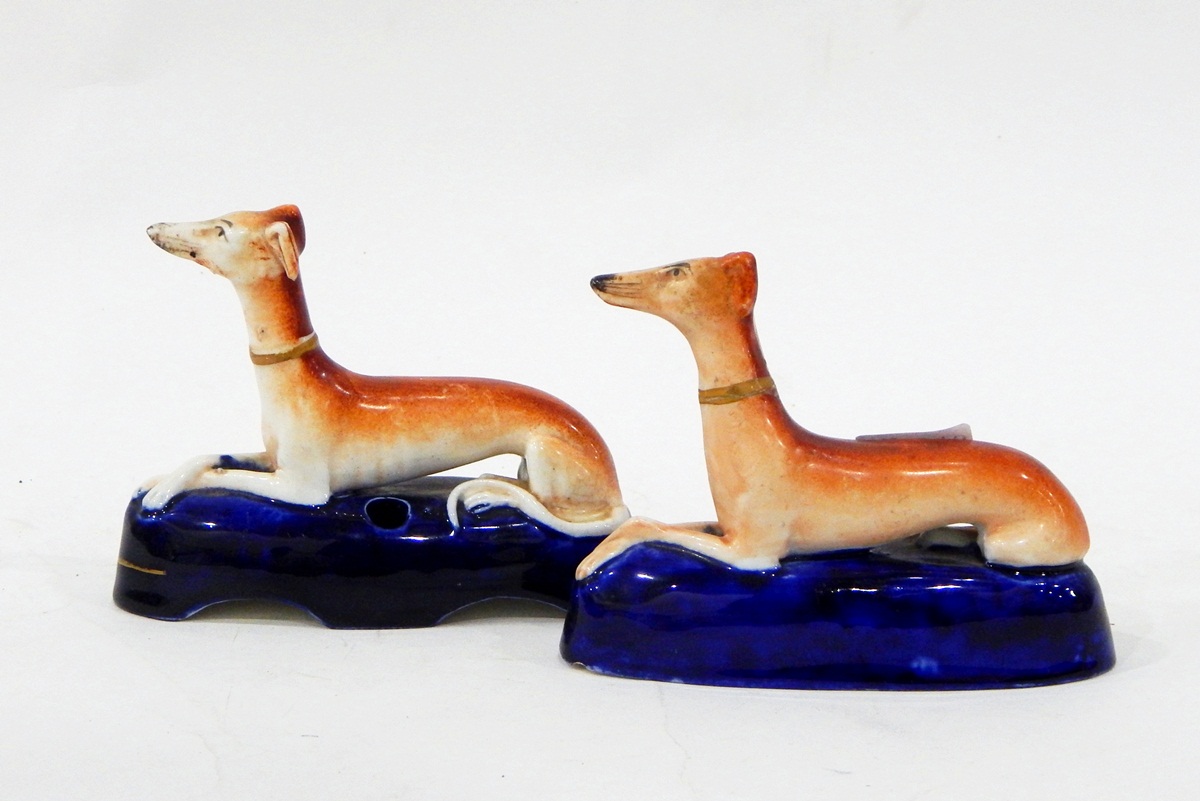 Pair of Staffordshire models of recumbent greyhounds and a pair of Staffordshire pen stands