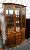 A modern display cabinet with drawers and cupboards to base,