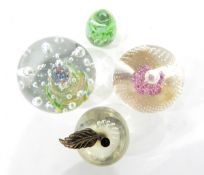 Glass paperweight, with central pink flower decoration, four further glass paperweights,
