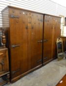 Part bedroom suite comprising two two-door oak wardrobes of Gothic influence and three bedside