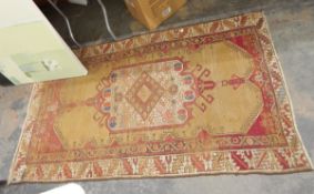 Antique Persian-style rug, the ochre ground with lozenge central medallion within hooked panel,