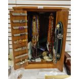 Wooden jewellery cabinet and contents of costume jewellery including amber beads, haematite beads,