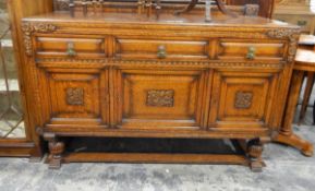 Early 20th century oak sideboard with carved ornamentation, panelled doors and on turned supports,