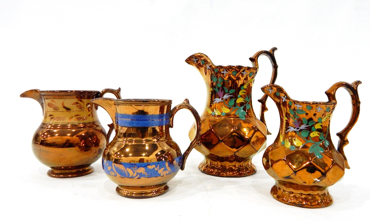 Set of three graduated copper lustre jugs with faceted bodies and painted floral decoration,