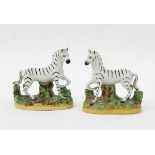 Pair of Staffordshire models of zebras on naturalistic oval bases,