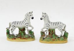 Pair of Staffordshire models of zebras on naturalistic oval bases,
