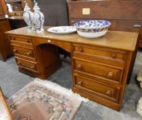 A 20th century oak kneehole dressing table with three drawers to each pedestal, turned knob handles,