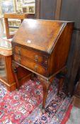 Lady's early 20th century walnut veneered bureau with fitted interior and the fall over two drawers,