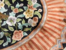 Chinese wool rug, oval, the black ground with floral central medallion,