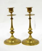 A pair of late Georgian brass candlesticks with knopped stems, on circular bases,
