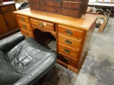 An Edwardian mahogany kneehole pedestal desk having an arrangement of nine drawers,