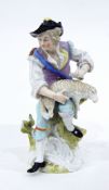 Continental porcelain figure of a man seated on a tree stump shearing sheep,