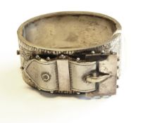 An Eastern silver-coloured and turquoise bangle in stylised flowerhead and mask pattern with beaded