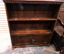 Oak open fronted bookcase with dentil cornice over two shelves, cupboard below, on bun feet,
