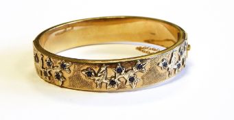 9ct gold and sapphire bangle applied with gold overlay bird and branch decoration set with