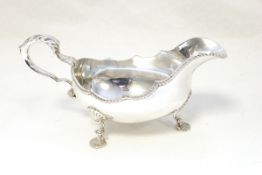 Silver sauce boat, oval with gadrooned border, foliate scroll handle,