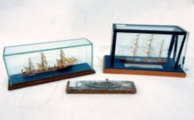 Two models of sailing ships on glass-topped stands and another model of a ship (3)