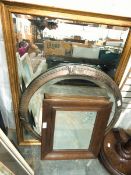 A circular mirror within an Art Nouveau style metal frame,