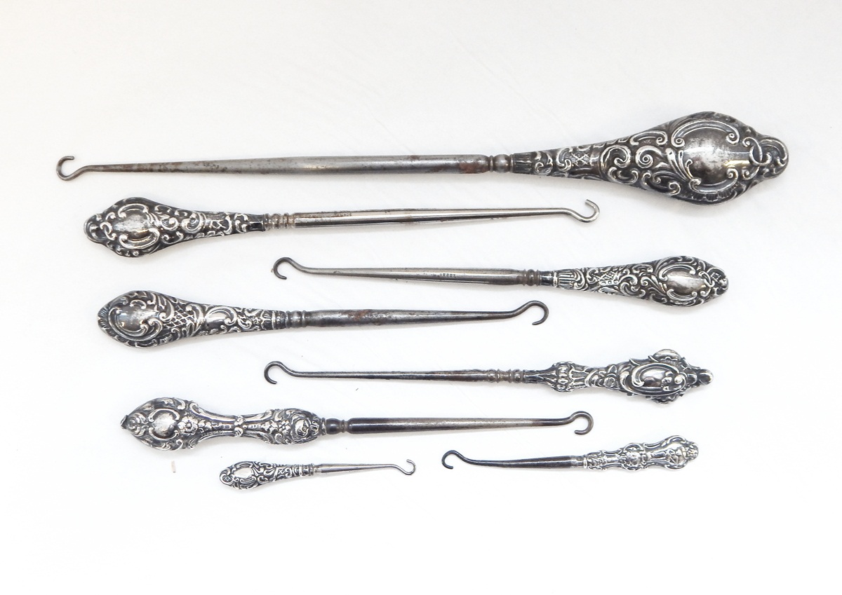 A collection of early 20th century silver handled button hooks,