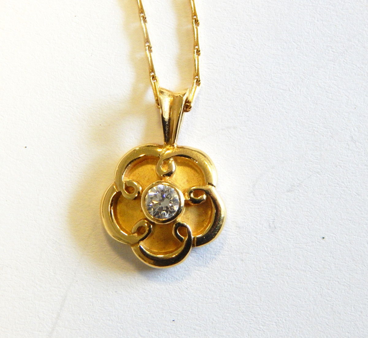 18ct gold and diamond solitaire flowerhead pendant, the centre set stone approx. 0.