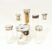 Seven George V silver-mounted cut glass toilet bottles and jars,