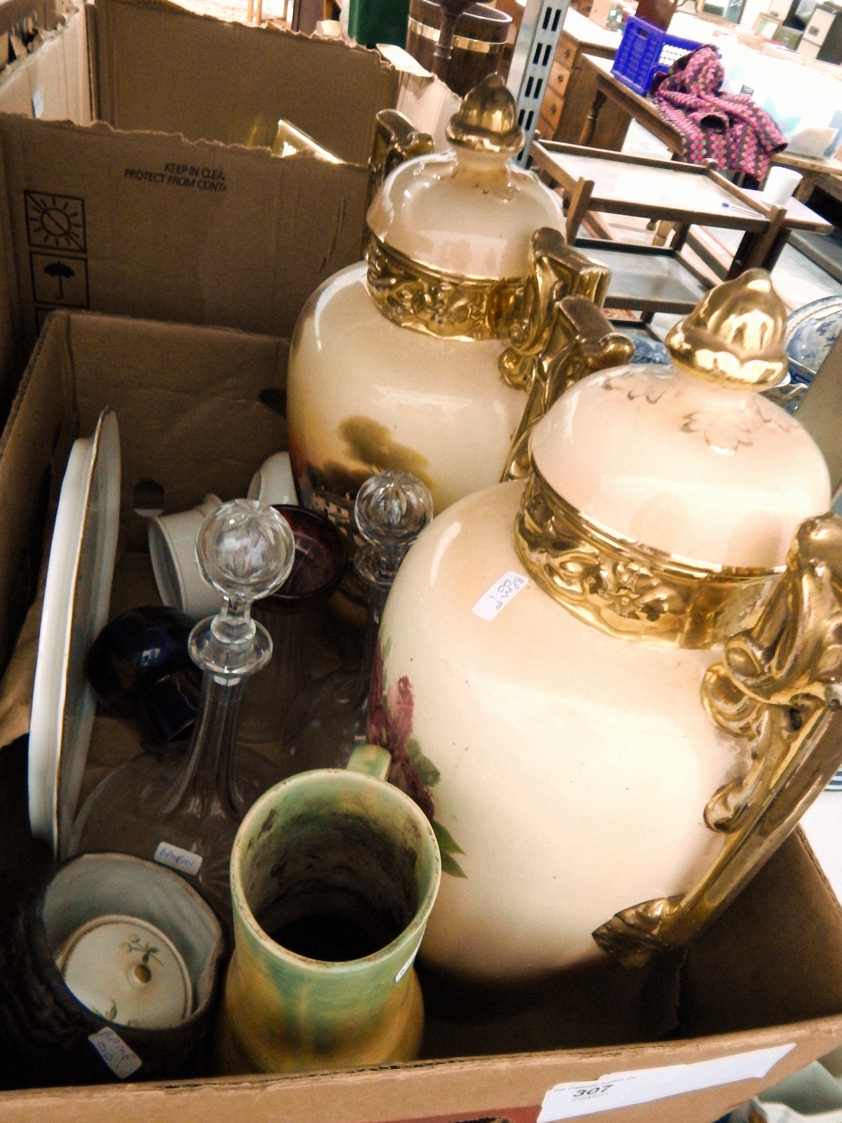 A pair of Victorian transfer printed decorated urns heavily gilded, a pair of glass decanters,