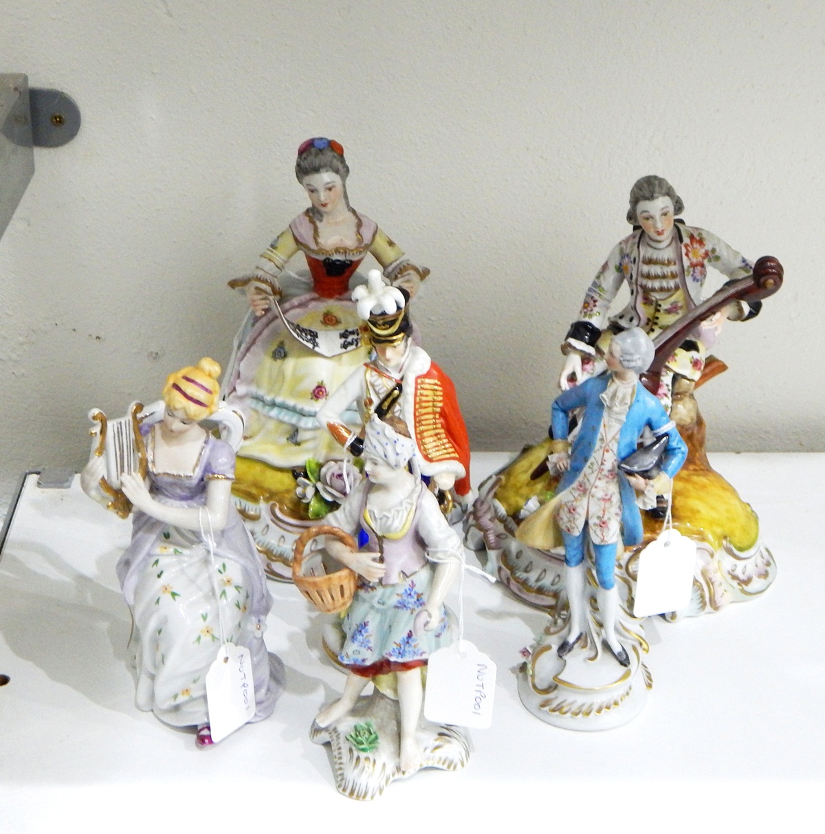 Pair of continental porcelain figures, one depicting a gentleman playing a cello,