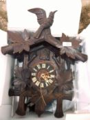 20th century oak cuckoo clock with floral decoration and bird finial to top