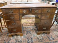20th century mahogany veneer kneehole writing desk with an arrangement of nine drawers,