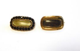 19th century gold coloured metal morning brooch with hair centre and facet cut black paste surround