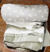 Box of various linens including a fabric covered bolster, two pairs of green curtains, etc.