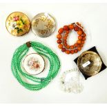 Quantity of costume jewellery to include a glass necklace, amber-style beads, compacts,
