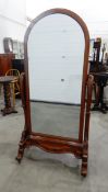 Victorian mahogany framed cheval mirror with carved scroll supports to splayed legs united by