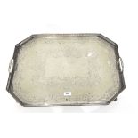 Silver plate octagonal tray with open fretwork border, foliate engraving, raised on scroll feet,