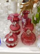 Collection of Victorian cranberry glass including a pair of jars and covers with applied clear