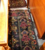 Handmade Eastern wool rug with dark ground, having beige geometric motifs to centre,