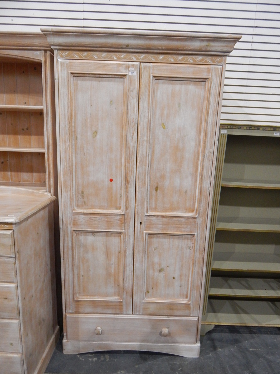 Limed-effect wardrobe with pair of panel doors enclosing hanging space, with long drawer below,