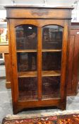 Oak glazed bookcase with panelled door enclosing shelves, on bracket feet,