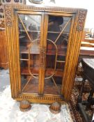 Oak glazed bookcase with pair panel doors enclosing shelves, with floral carved decoration,