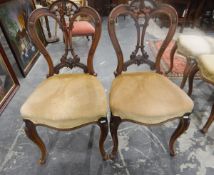 Set of four Victorian walnut balloon-back dining chairs with pierced splats,