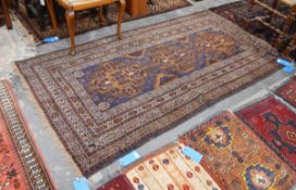 Handmade Eastern wool rug with blue ground, having three brown geometric motifs to centre,