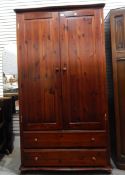 Stained pine wardrobe, the pair panel doors enclosing shelf and hanging space,